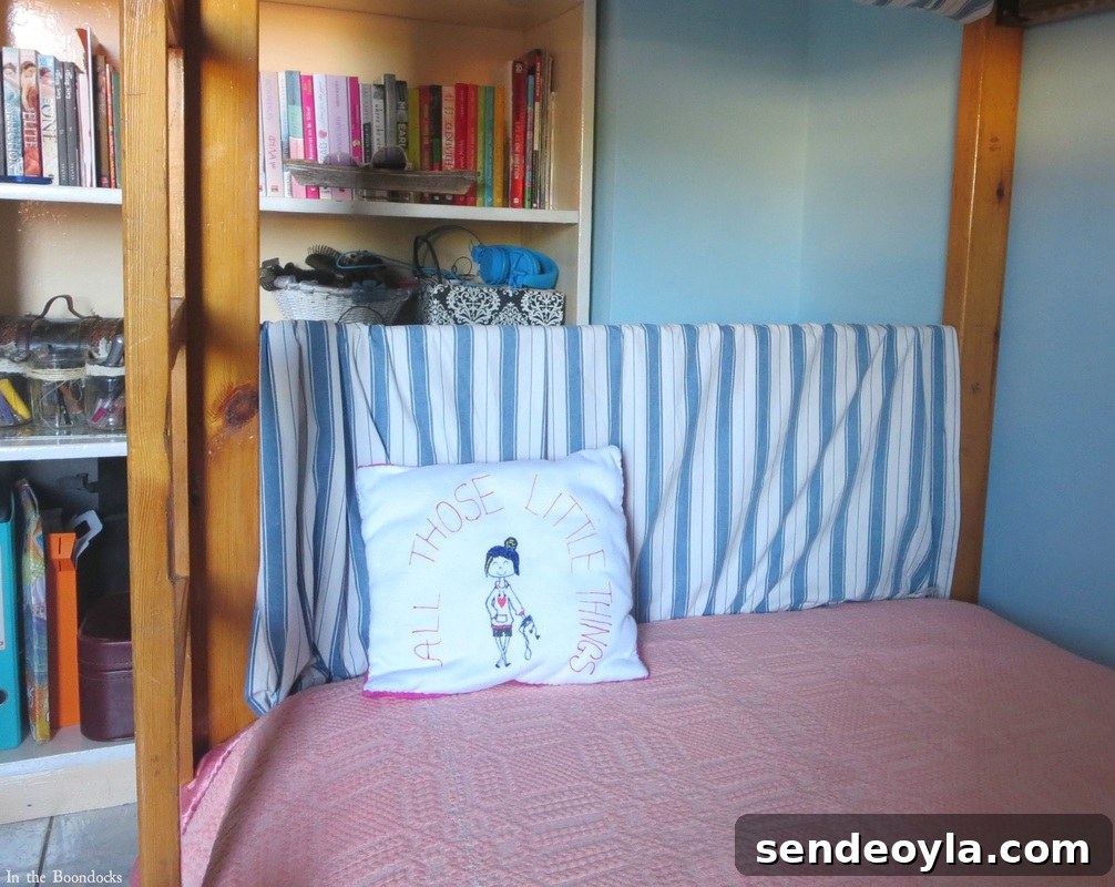 Adding blue striped fabric to the bed to tone down the wood, A Tour of the Blue Room www.theboondocksblog.com