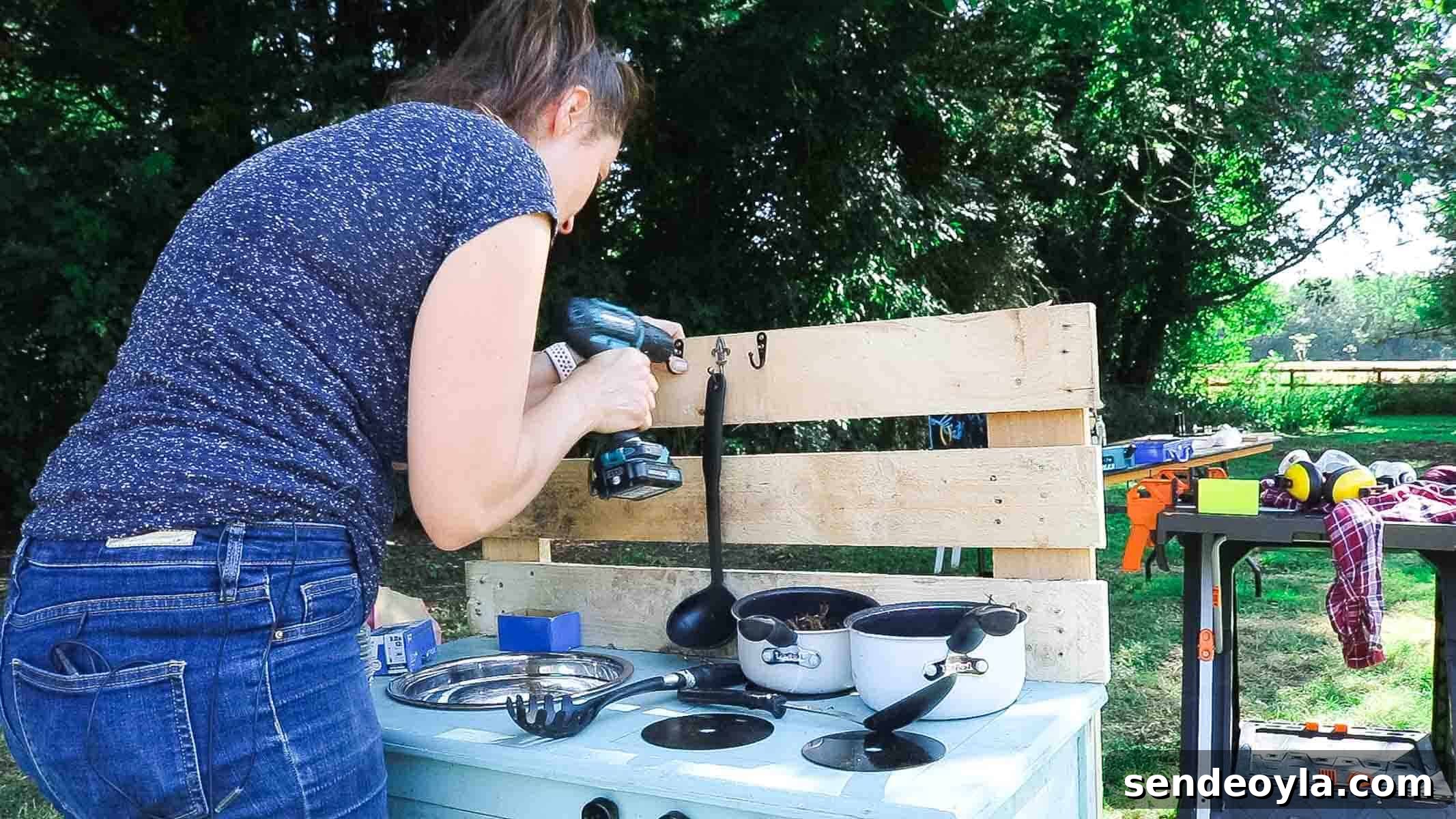 Screwing unused curtain tie back hooks on pallets for toy cooking utensils to hang