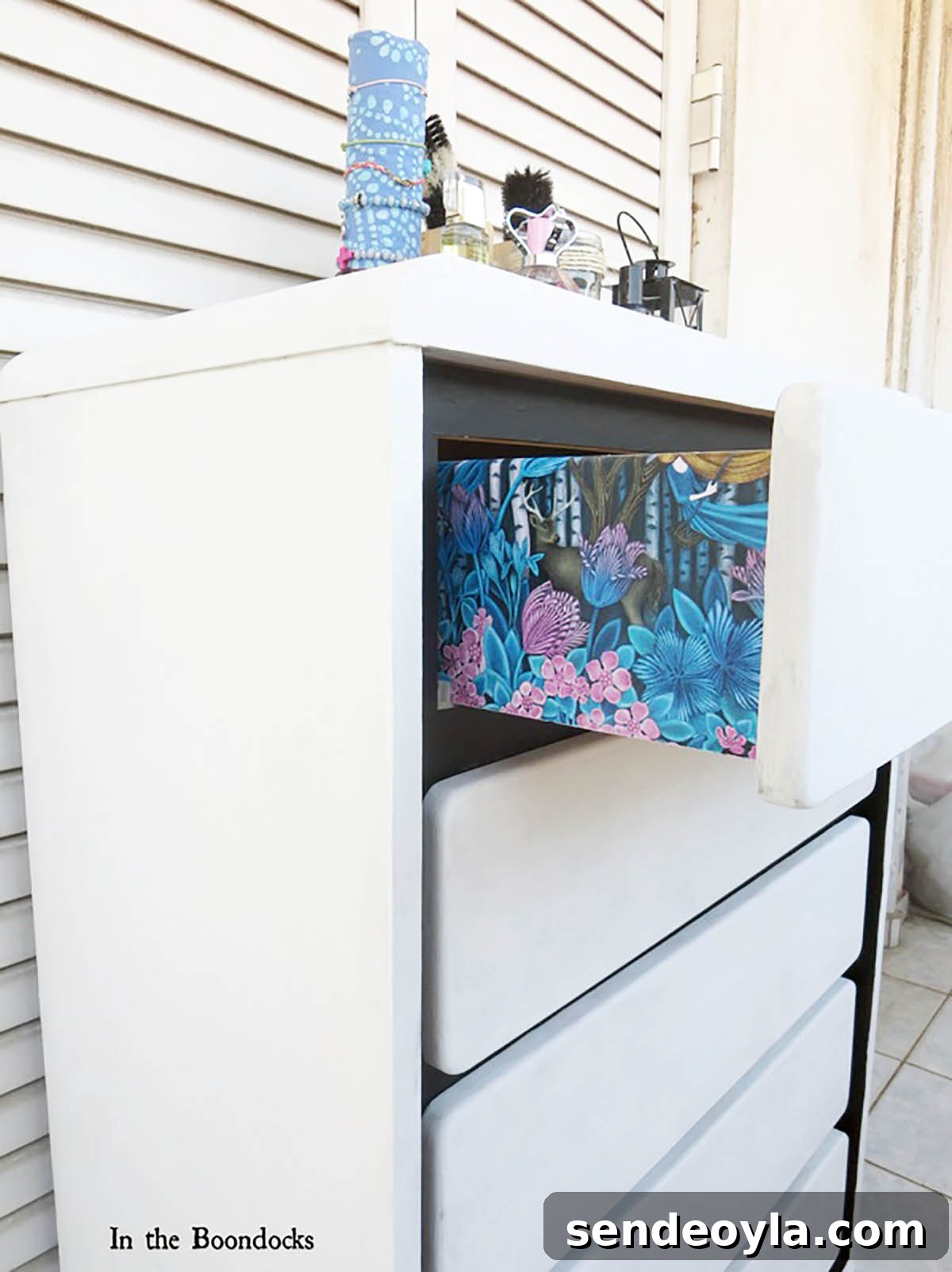 DIY Dresser Makeover: Paint and Decorative Paper Tutorial 2 A side view of the DIY dresser makeover featuring blue and pink floral gift wrap decoupaged on the sides of the drawers.