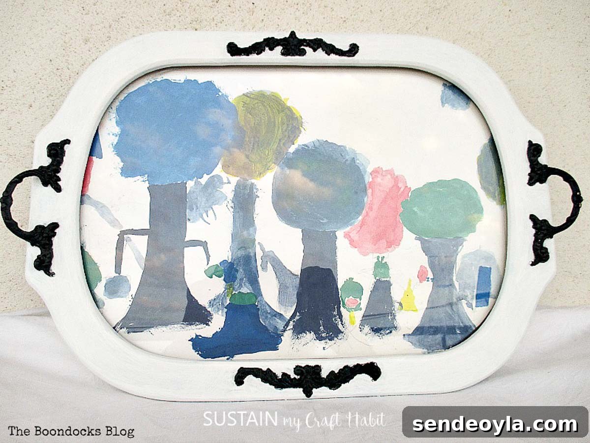 How to Upcycle a Vintage Serving Tray into a Stylish Home Accent 7 Completed upcycled serving tray showing a child's painting of trees behind the glass