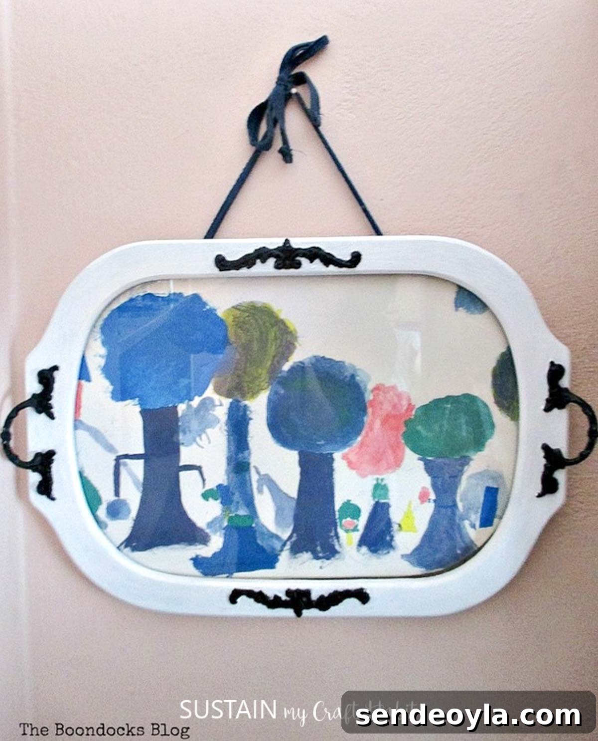 How to Upcycle a Vintage Serving Tray into a Stylish Home Accent 8 Child's artwork displayed behind the glass of a repurposed white serving tray