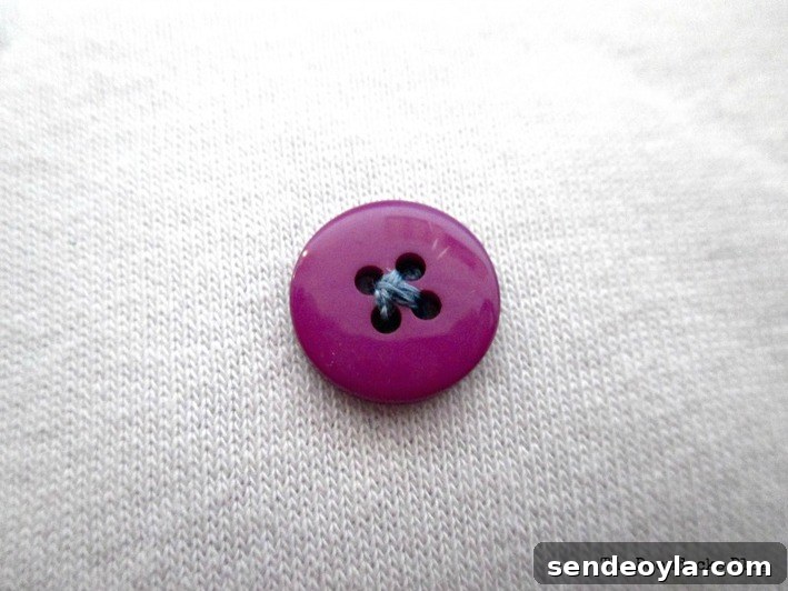 Button decoration on repurposed sweatshirt pillow