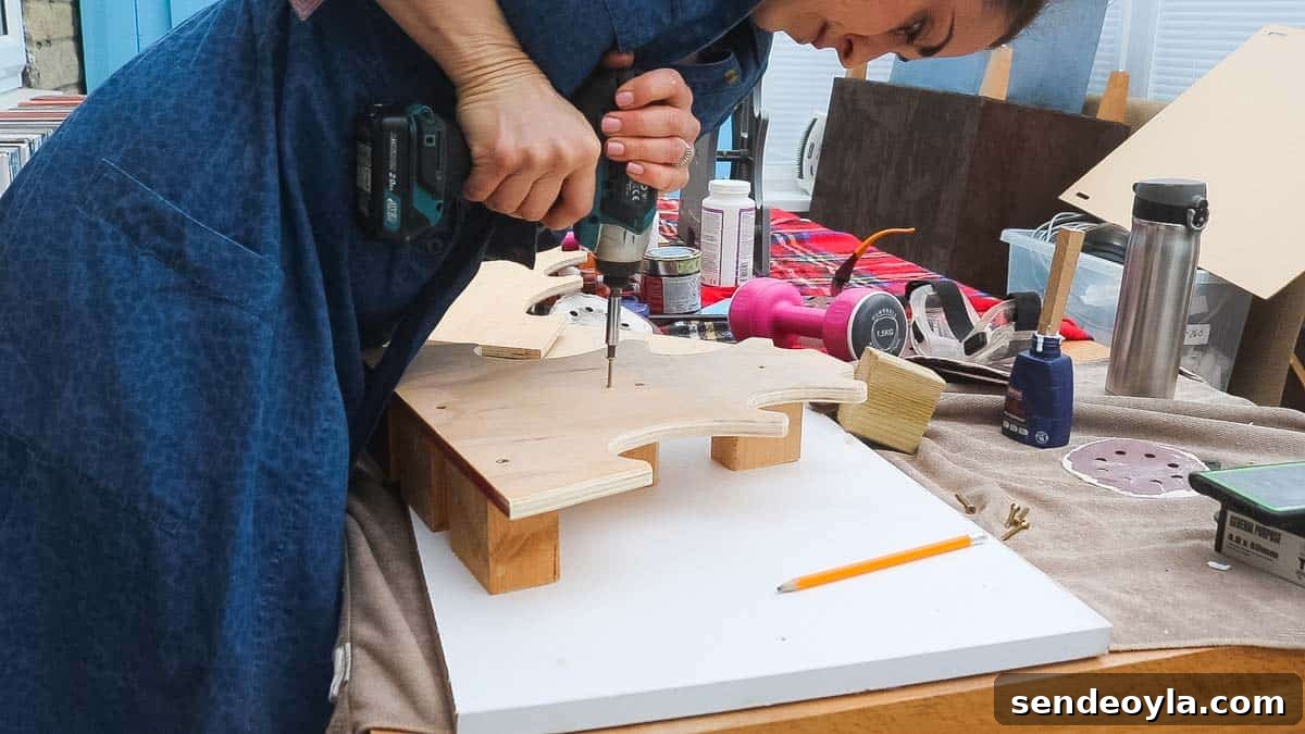 DIY Dumbbell Rack Tree Stand with Free Plans 12 Woman using an impact driver to screw a dumbbell tree to noggin blocks