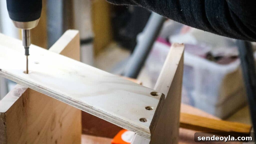 Screwing a middle shelf to create a small 3 tier wooden trolley for plastic baskets or shoe boxes