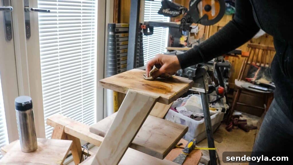 Rubbing dark furniture wax on untreated pine zig zag trolley cart with a lint free cloth
