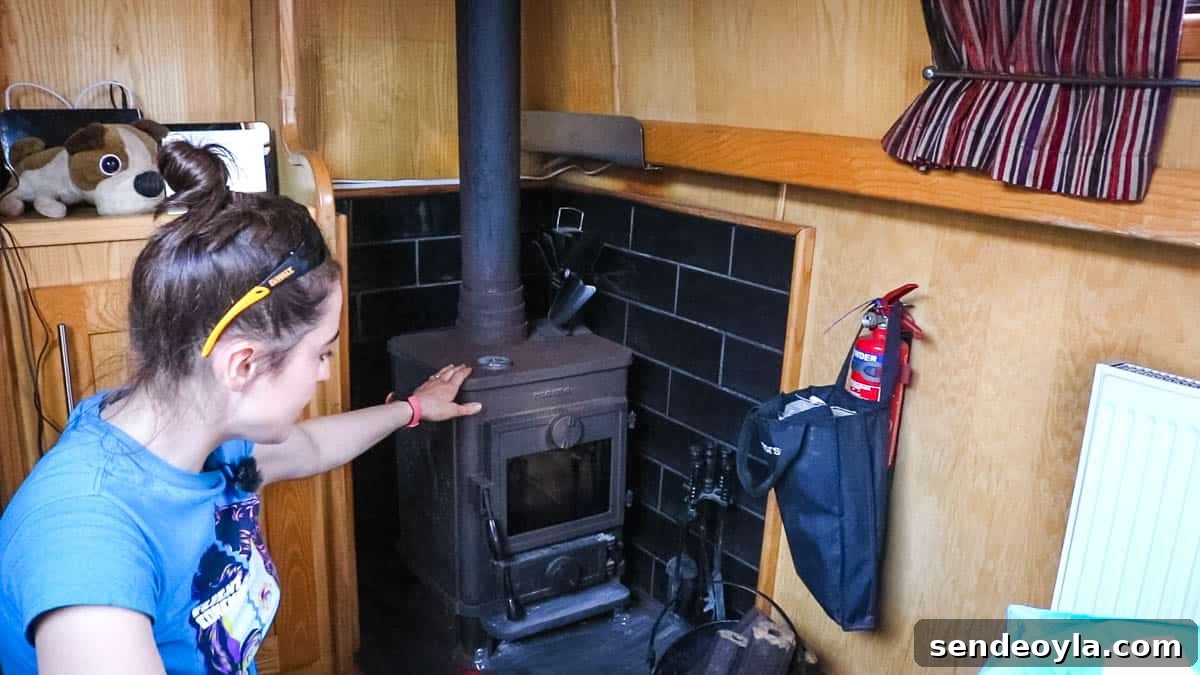 Inside a 57ft Reverse-Layout Narrowboat: Interior Tour 14 Woman in front of Morso Multi Fuel Stove on a 57ft boat