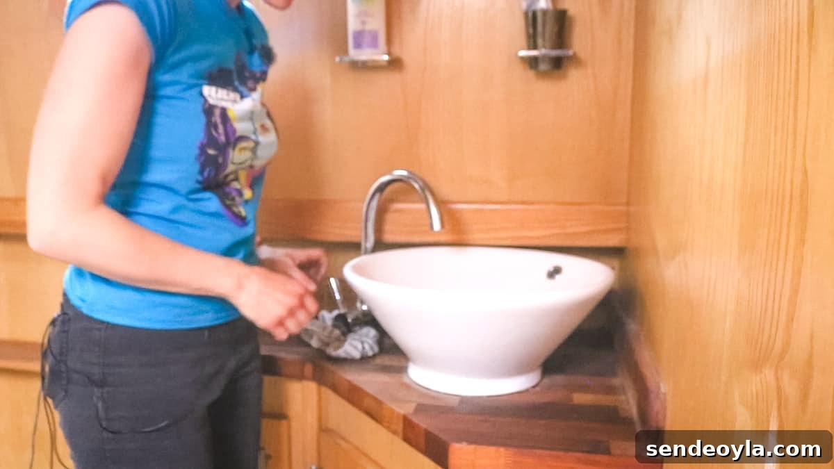 Inside a 57ft Reverse-Layout Narrowboat: Interior Tour 17 Woman stood in The Head (AKA a boat bathroom), in front of vessel sink