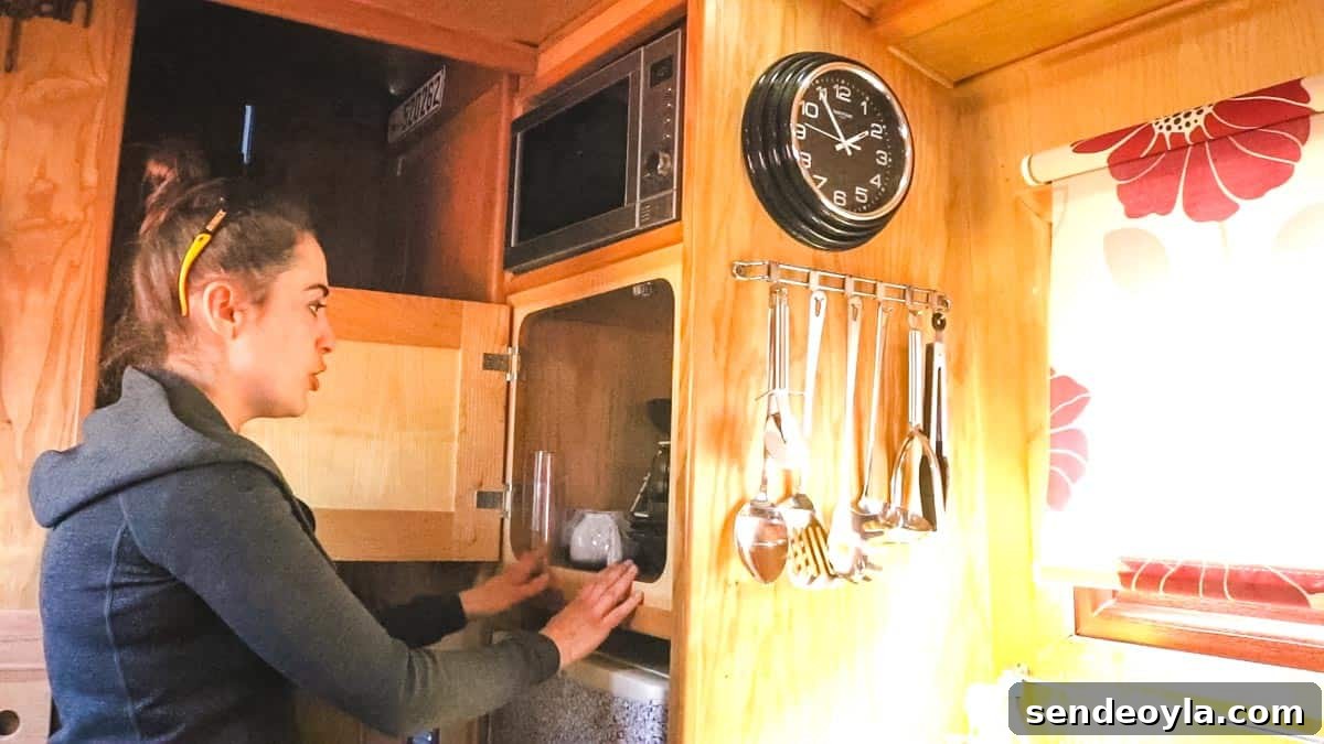 Inside a 57ft Reverse-Layout Narrowboat: Interior Tour 7 Woman opening narrowboat kitchen cupboard above fridge