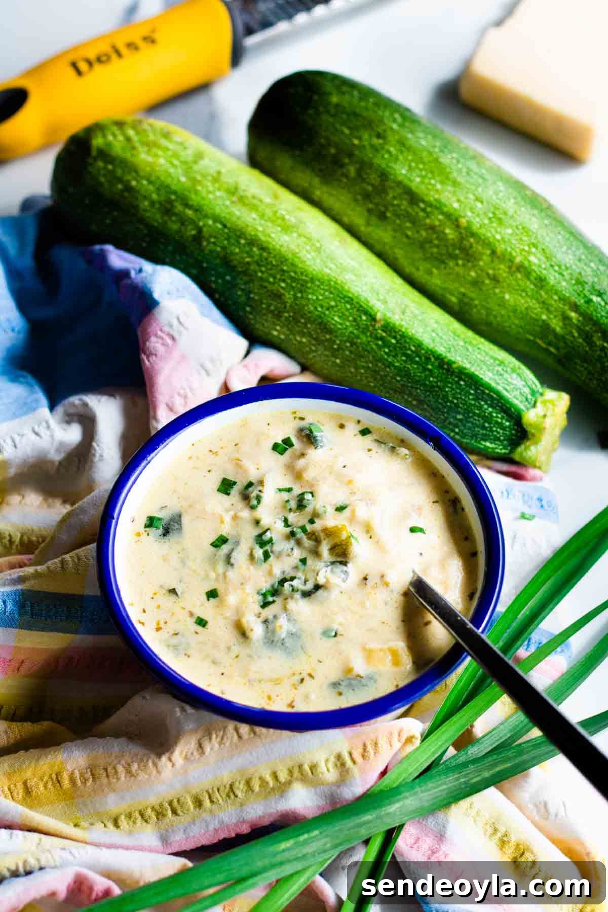 Chunky Keto Zucchini and Cheese Soup 2 Bowl full of Keto creamy cheesy courgette soup in Falcon enamel bowl on white marble worktop.