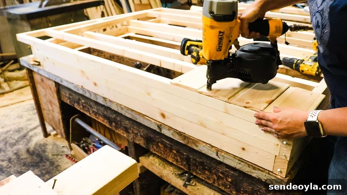 How to Build a Lean-To Shed with Free Plans 5 Cladding a shed with a nail gun in a woodyard