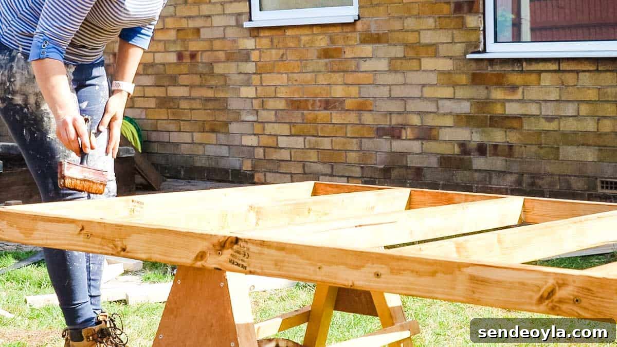 How to Build a Lean-To Shed with Free Plans 7 Woman treating a shed base