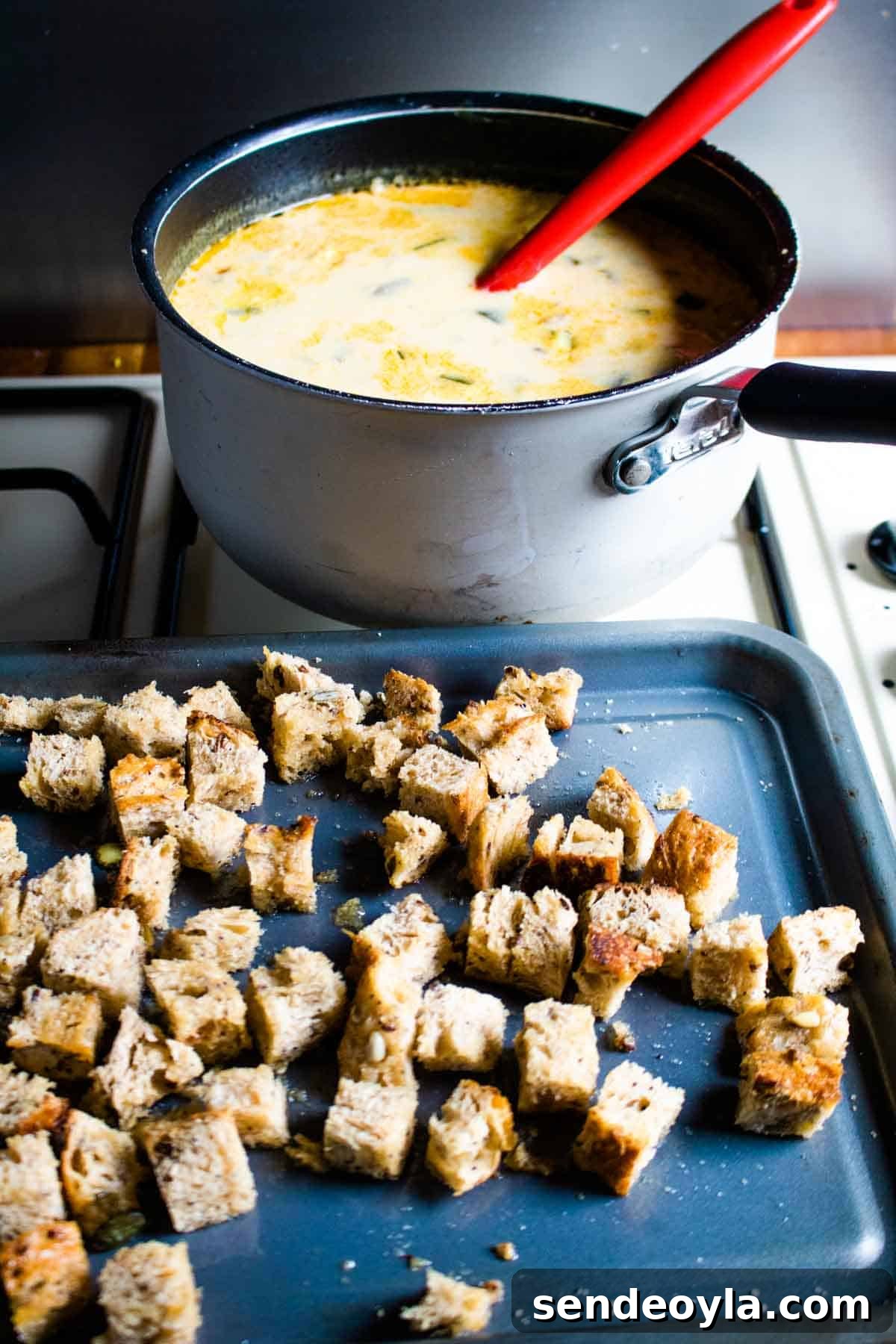 Hearty Cheesy Bacon and Chorizo Bread Soup Recipe 4 Soup cooking in a saucepan before toasted sourdough is stirred in