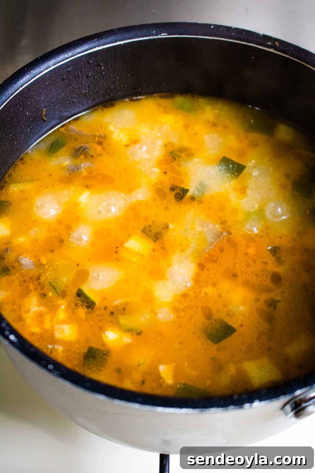 Hearty Cheesy Bacon and Chorizo Bread Soup Recipe 5 Bacon and chorizo soup simmering in a pan without cream or cheese