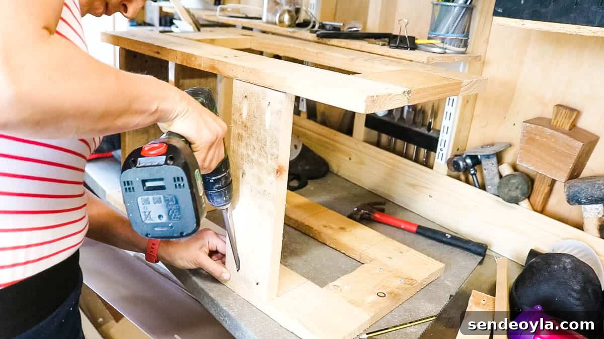 DIY Drawer Boxes for Workshop Storage: Step-by-Step Plans 8 Woman screwing a pallet support at back for drawer frame to make more rigid.