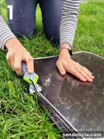 person scraping old window sealant off plastic windows