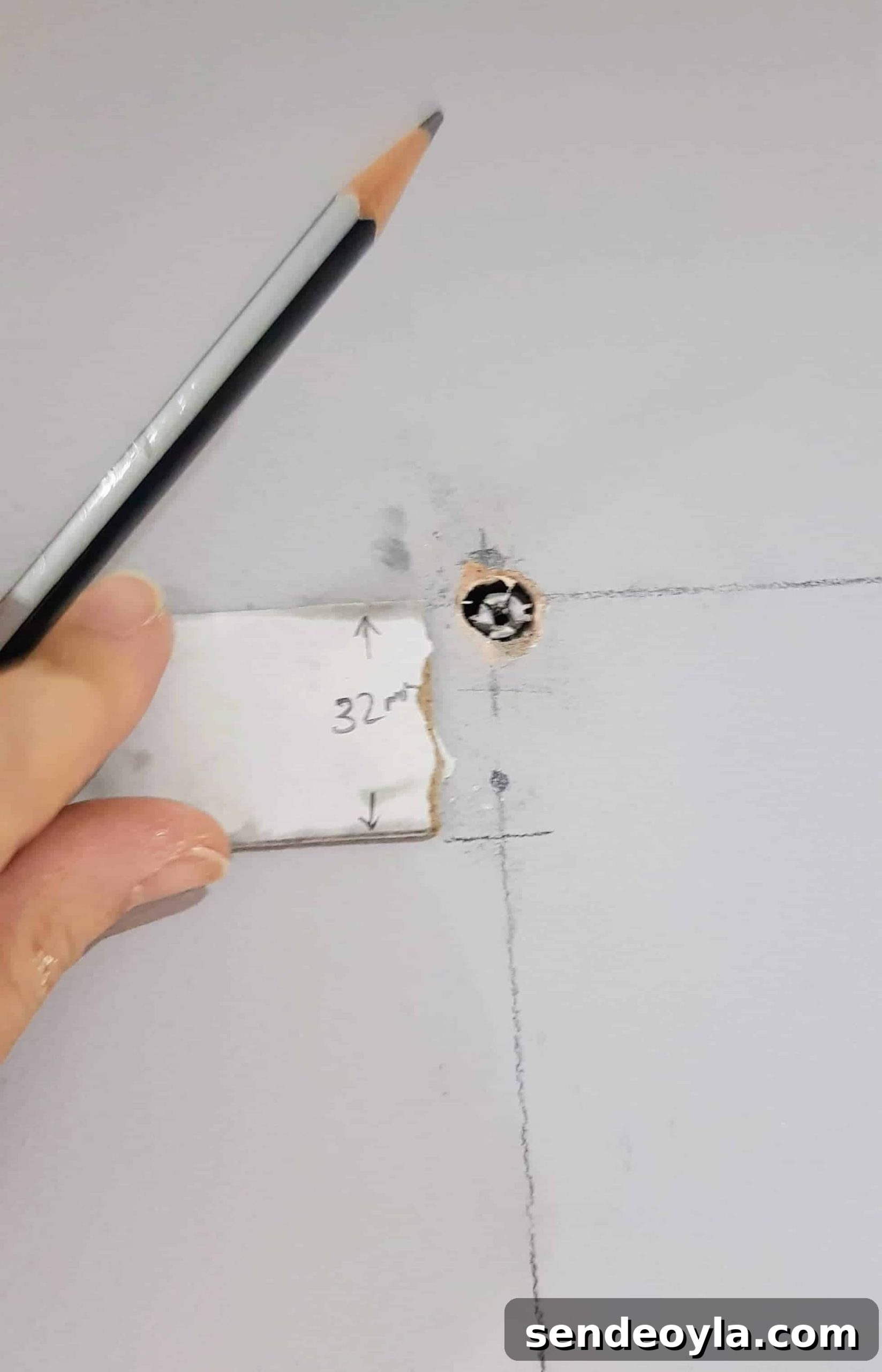 How to Install a Curtain Pole Batten with Grab Adhesive 6 Marking wall with scrap card.