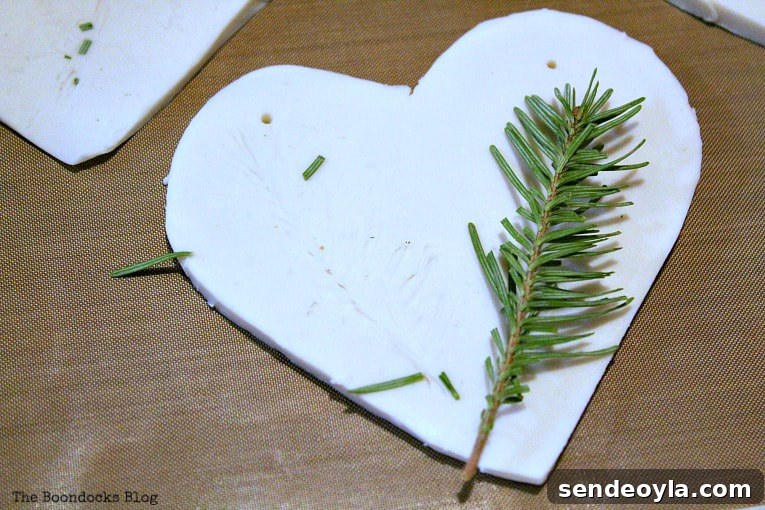 Pressing pine sprigs into clay for texture