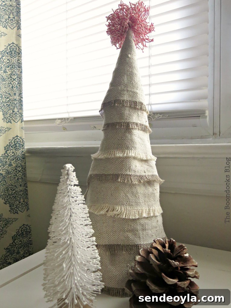 DIY Mini Christmas Tree from Dollar Store Fabric 2 Mini Christmas tree made with fabric scrap fabric beside a miniature white tree and a pine cone.