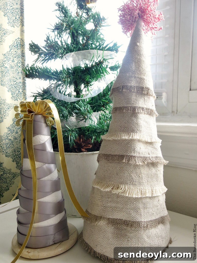 DIY Mini Christmas Tree from Dollar Store Fabric 14 Mini Christmas tree made with fabric scraps beside a grey and gold ribbon wrapped into a Christmas tree shape. Both are placed in front of a miniature potted evergreen tree.