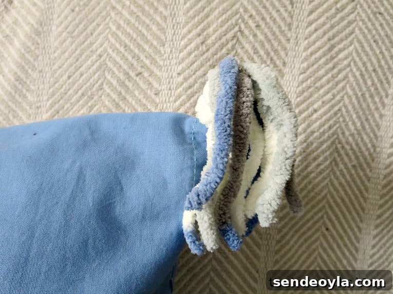 DIY Throw Pillows from Fabric Scraps: 5 Creative Ideas 13 close up of yarn tassels, How to Make Easy Pillows out of Fabric Remnants 5 ways www.theboondocksblog.com