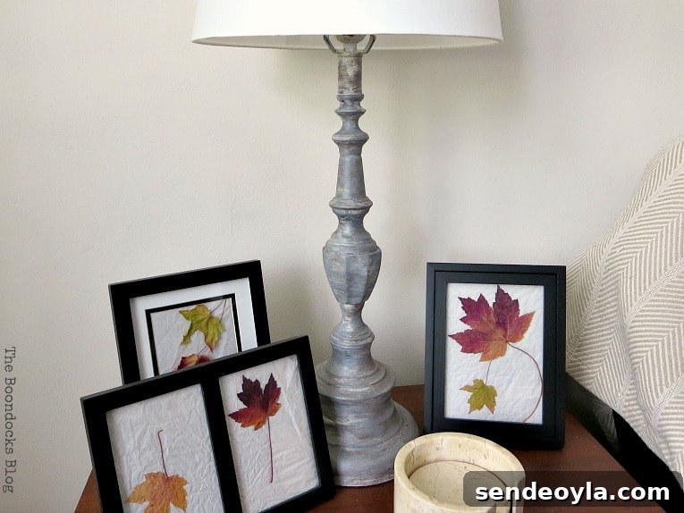 Turn a Lamp Base Into Faux Stone with Paint 12 Painted lamp base on wood table with framed pictures of leaves.