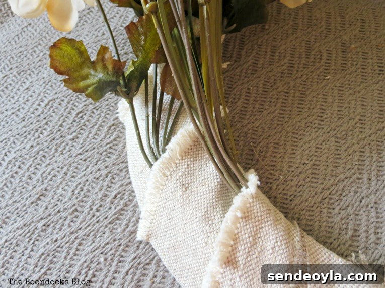 DIY Dollar Store Fall Wreath: Step-by-Step Guide 8 Placing the faux flowers into the fabric strips on the wire form.