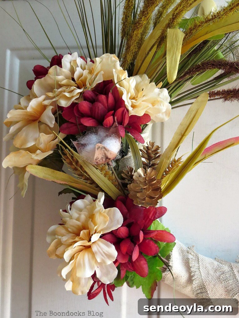 DIY Dollar Store Fall Wreath: Step-by-Step Guide 10 Close up of faux flowers and pine cones on the wreath.