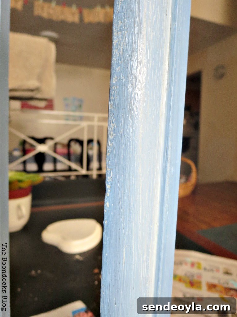 Transform Vintage Book Trough into Stylish Decor 5 Painting the wooden book shelf with blue paint.