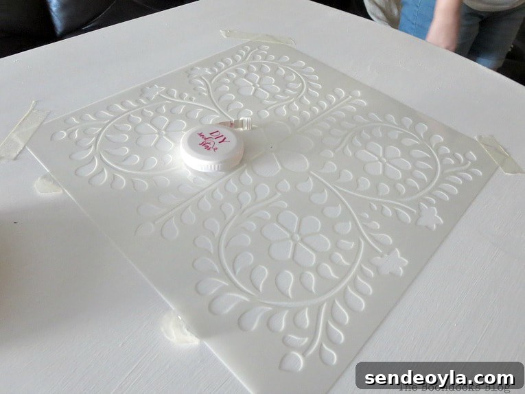 Positioning stencil on table which has been painted white, How to Give your Old Table a New Look with Stencils
