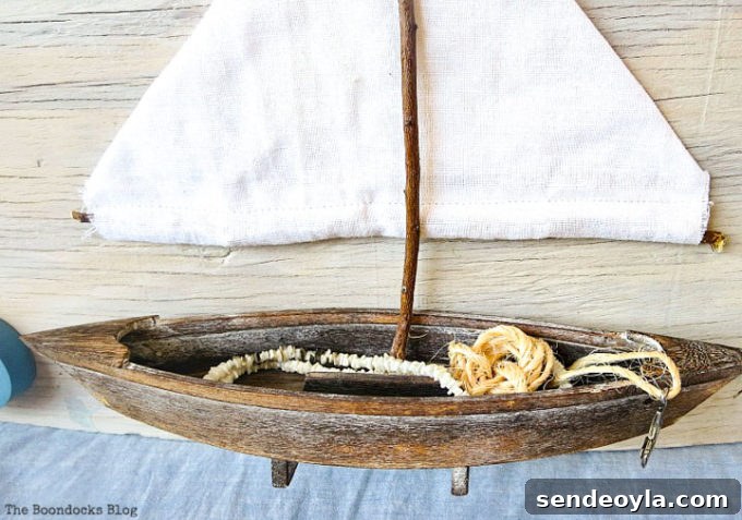 Coastal Wall Art Made from Repurposed Beach Finds 15 Close-up of the small boat inside the DIY beach art