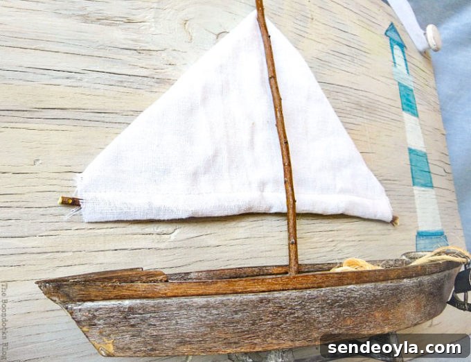 Coastal Wall Art Made from Repurposed Beach Finds 16 Vintage-looking sailboat detail in seaside wall art