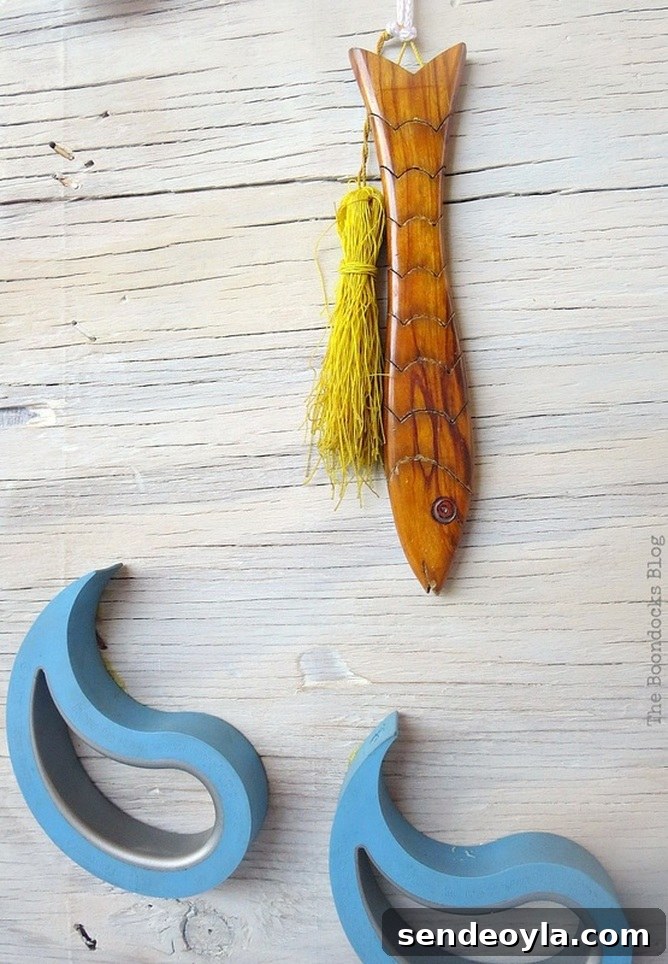 Coastal Wall Art Made from Repurposed Beach Finds 17 Fish ornament positioned above the wave shapes