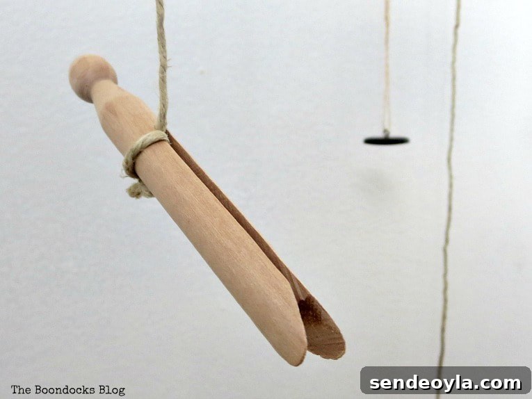 Attaching various objects on the bottom with twine, including a wooden clothes pin