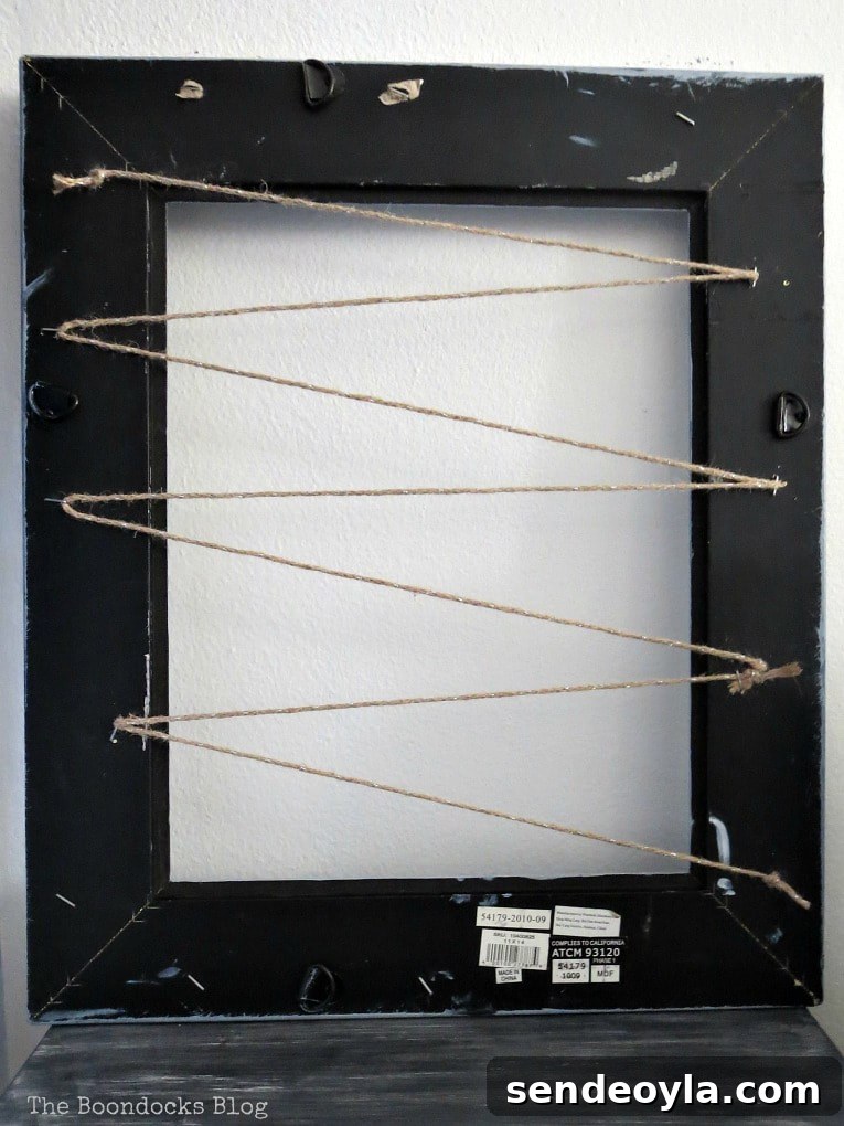The back of the picture frame with the twine zigzagging
