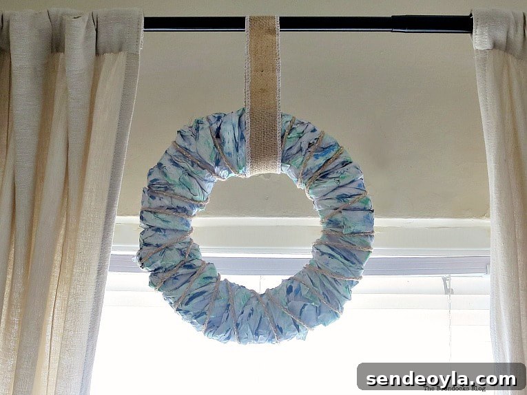 Colorful packing paper wreath hung on curtain rod.