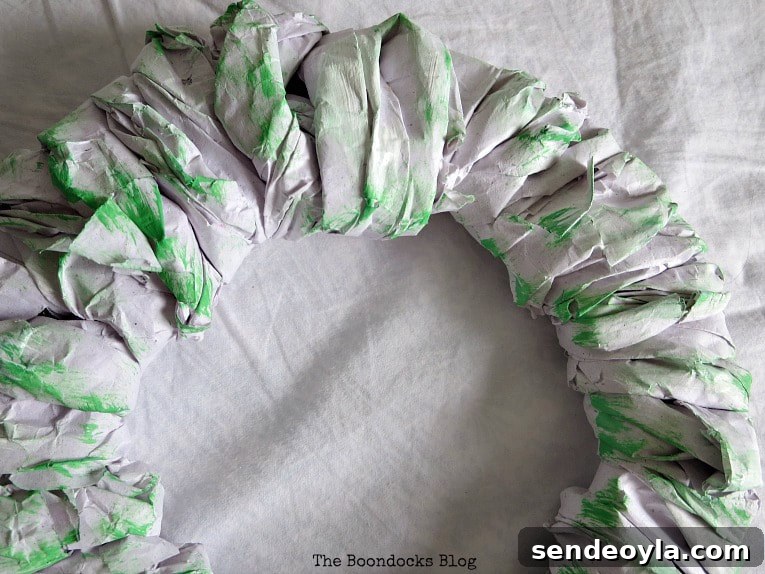 Adding green paint on the wrapped packing paper.