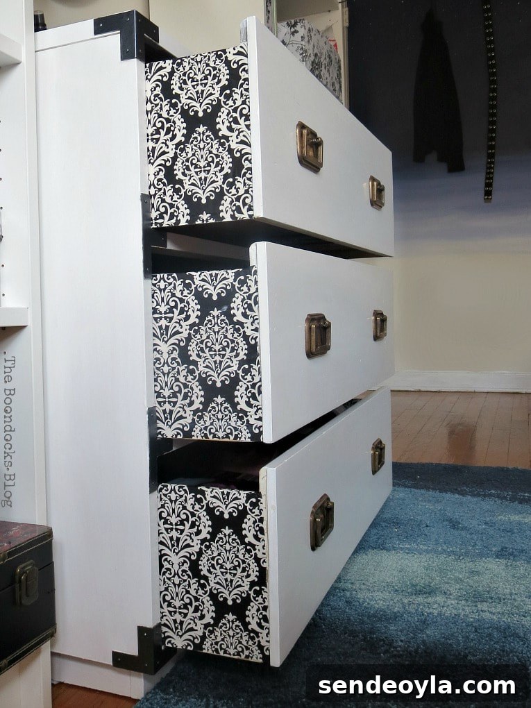 Refinish and Restore a Campaign Dresser in 7 Steps 12 Side view of the upcylced dresser with Damask paper on the sides of drawers.