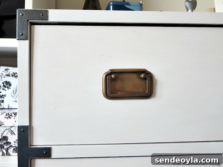 Refinish and Restore a Campaign Dresser in 7 Steps 8 Close up of brass handles and painted hardware on sides of dresser.