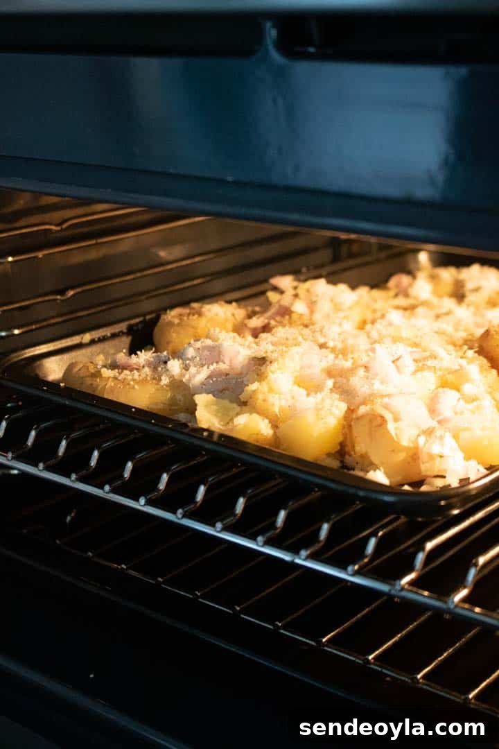 Crushed potatoes on a baking tray in the oven
