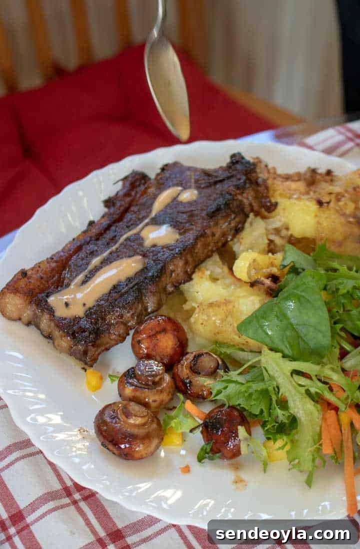 Drizzling Diane sauce on South Ormsby Estate steaks with crushed potatoes, mushrooms and salad