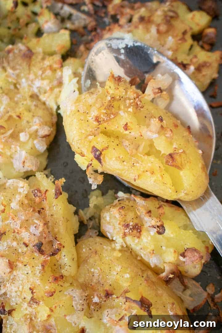 Spoon of crushed potatoes with Parmesan and shallots on baking tray