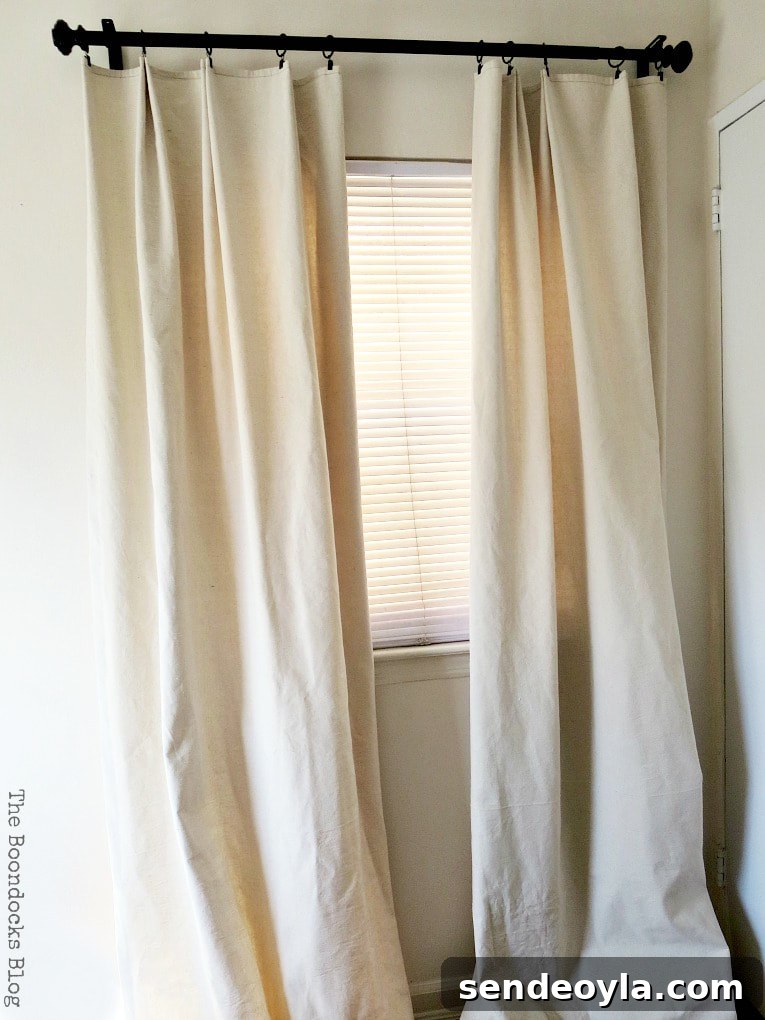DIY Pleated Drop Cloth Curtains: Step-by-Step Guide 2 Finished drop cloth curtains hanging in a room