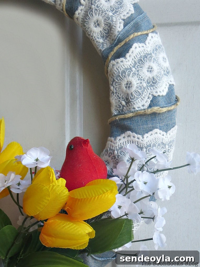 Spring wreath in front of door with flowers, ribbon and a red cardinal