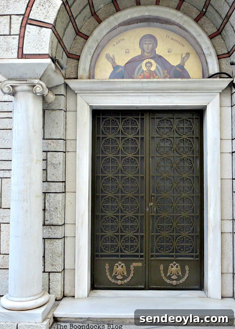 Church door with circular metal work and icon on the arch top
