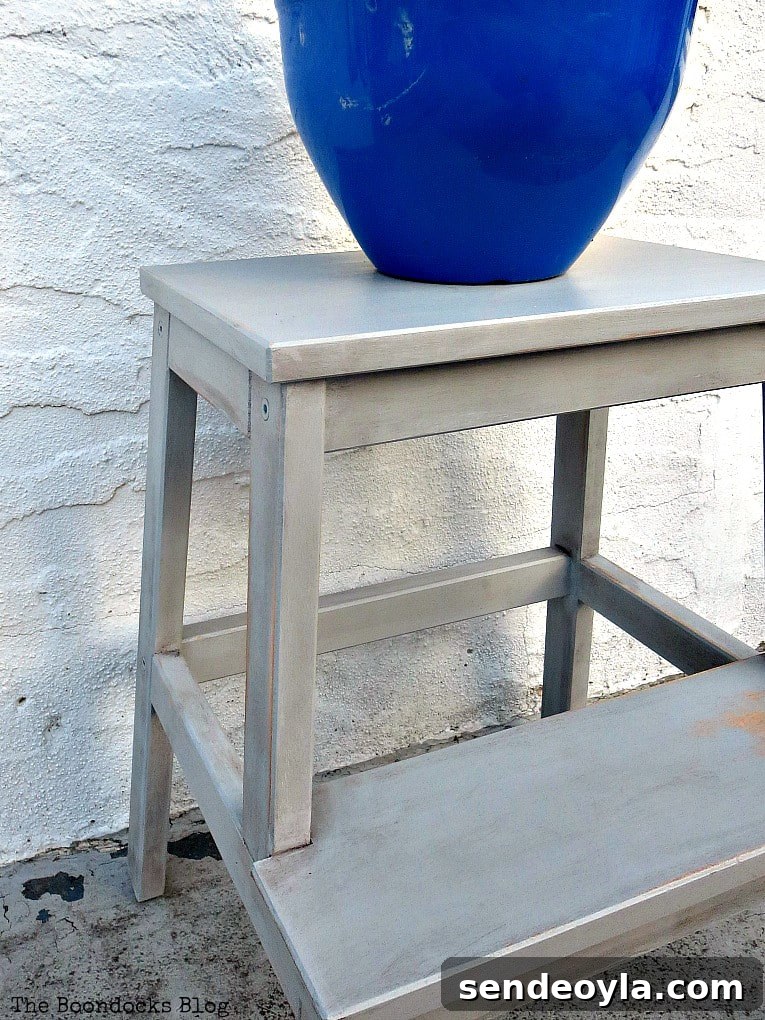 The Ikea stool, painted grey, with a  blue planter on top.