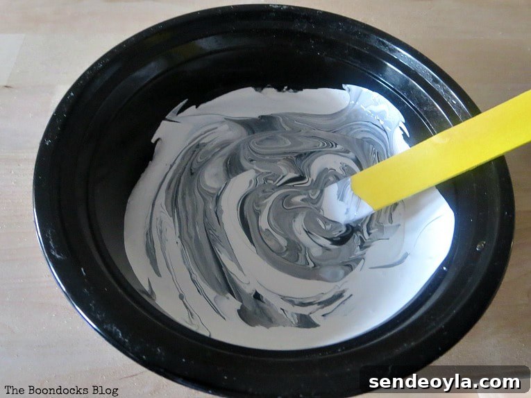 Mixing white chalky paint with black acrylic paint.