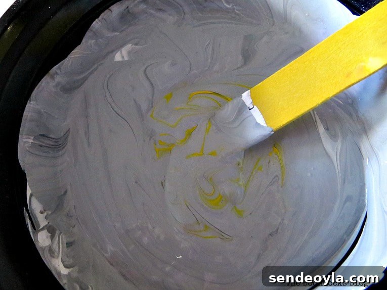 Adding yellow paint to the gray mixture.