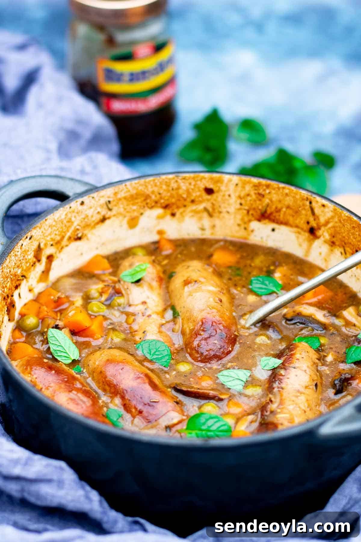 Branston Pickle Sausage Casserole Recipe 8 Close up of sausages, mushrooms, peas, onions and carrots in a Branston pickle gravy sauce