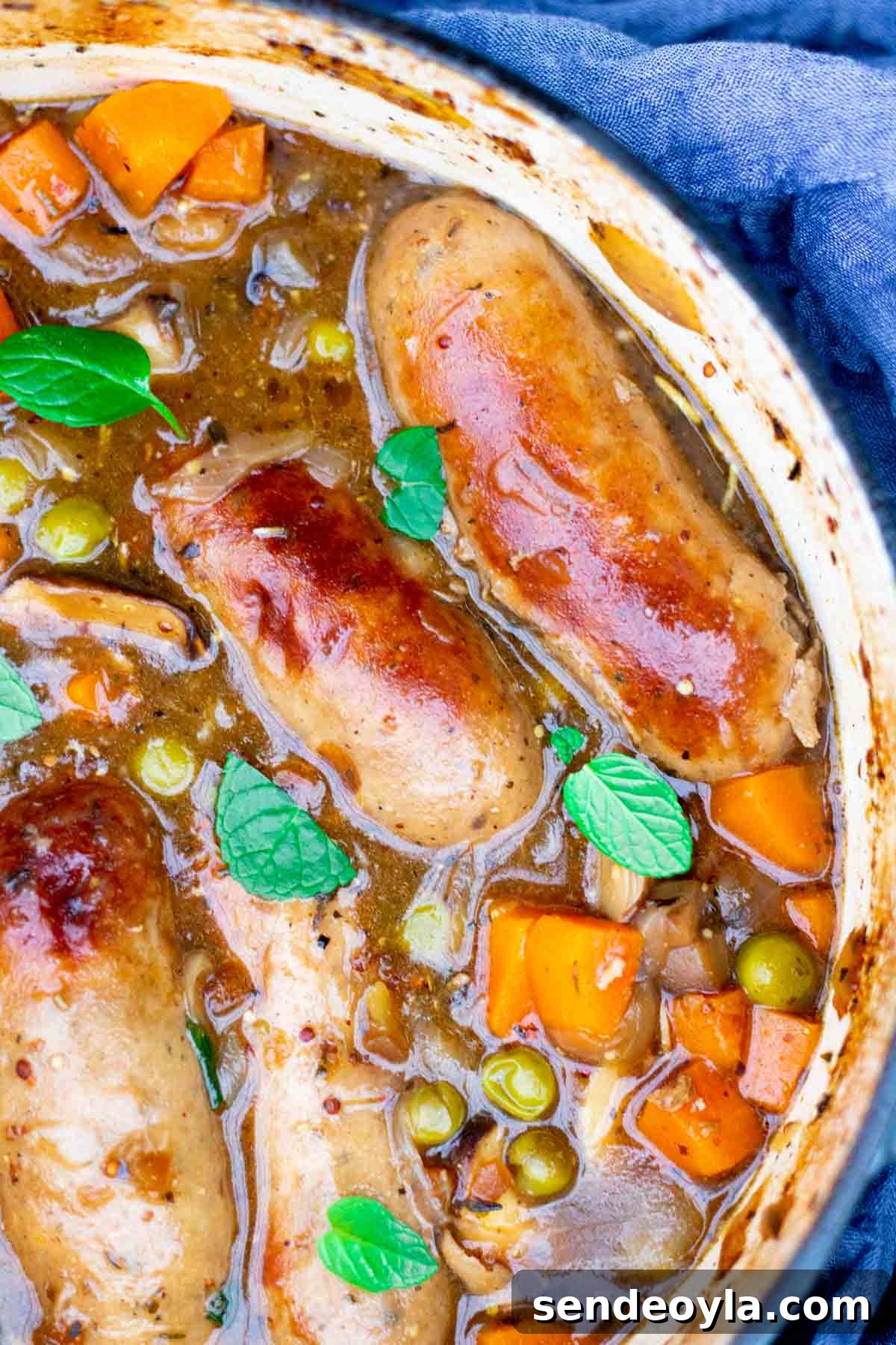 Branston Pickle Sausage Casserole Recipe 9 Close up of sausage stew in a cast iron pot with vegetables