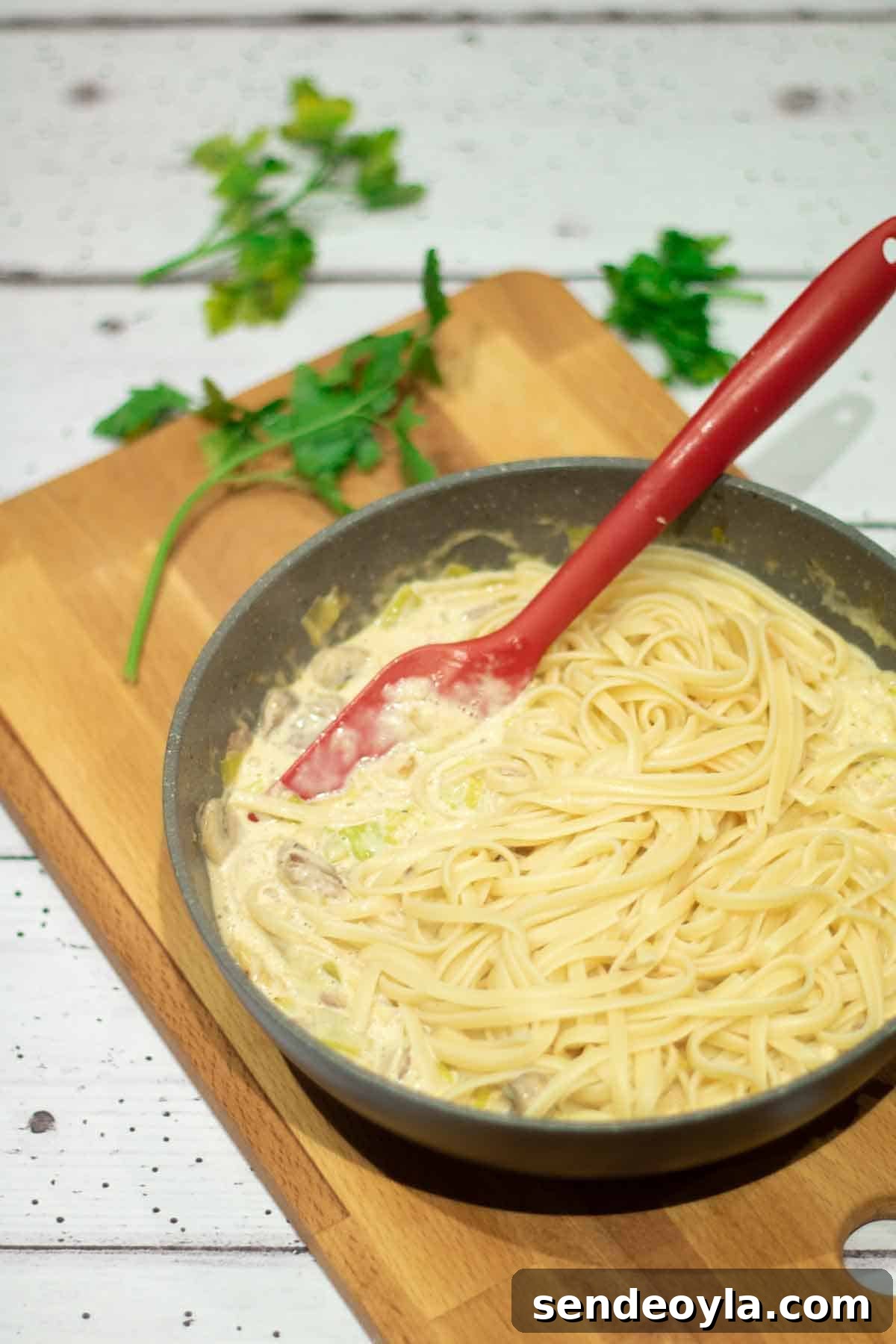 Cheesy Leek and Bacon Linguine 4 leeks and cream getting mixed together with linguine in a large deep frying pan